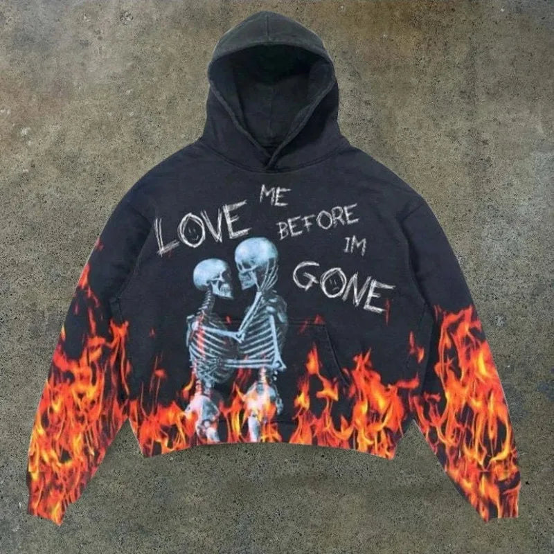 A black, polyester Explosions Printed Skull Y2K Retro Hooded Sweater Coat Street Style Gothic Casual Fashion Hooded Sweater Men's Female with a graphic of two skeletons embraced, surrounded by flames, and the text "LOVE ME BEFORE I'M GONE" written between them. This punk style men's hoodie by Maramalive™ makes a bold statement.