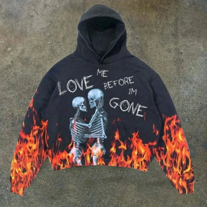 A Maramalive™ Explosions Printed Skull Y2K Retro Hooded Sweater Coat Street Style Gothic Casual Fashion Hooded Sweater Men's Female in punk style featuring an image of two skeletons embracing, surrounded by flames, with the text "LOVE ME BEFORE I'M GONE" written on it. Perfect for all four seasons.