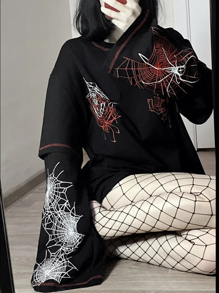 A person sitting on the floor, wearing a Maramalive™ Deeptown Y2k Gothic Spider T Shirt Women Goth Dark Streetwear Design Tees Black Long Sleeve Top 2023 Autumn Spring with red and white spider web designs, paired with fishnet stockings.