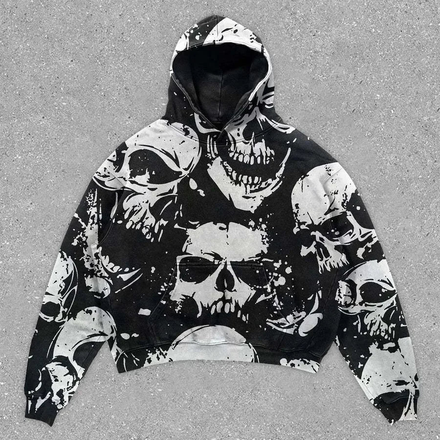A Maramalive™ Explosions Printed Skull Y2K Retro Hooded Sweater Coat Street Style Gothic Casual Fashion Hooded Sweater Men's Female with white skull graphic designs scattered across it, epitomizing punk style, displayed on a gray, textured surface.