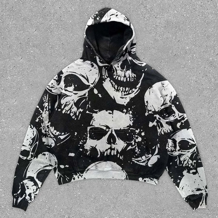 A Maramalive™ Explosions Printed Skull Y2K Retro Hooded Sweater Coat Street Style Gothic Casual Fashion Hooded Sweater Men's Female, black with multiple white skull designs printed on it, laid flat on a gray concrete surface.