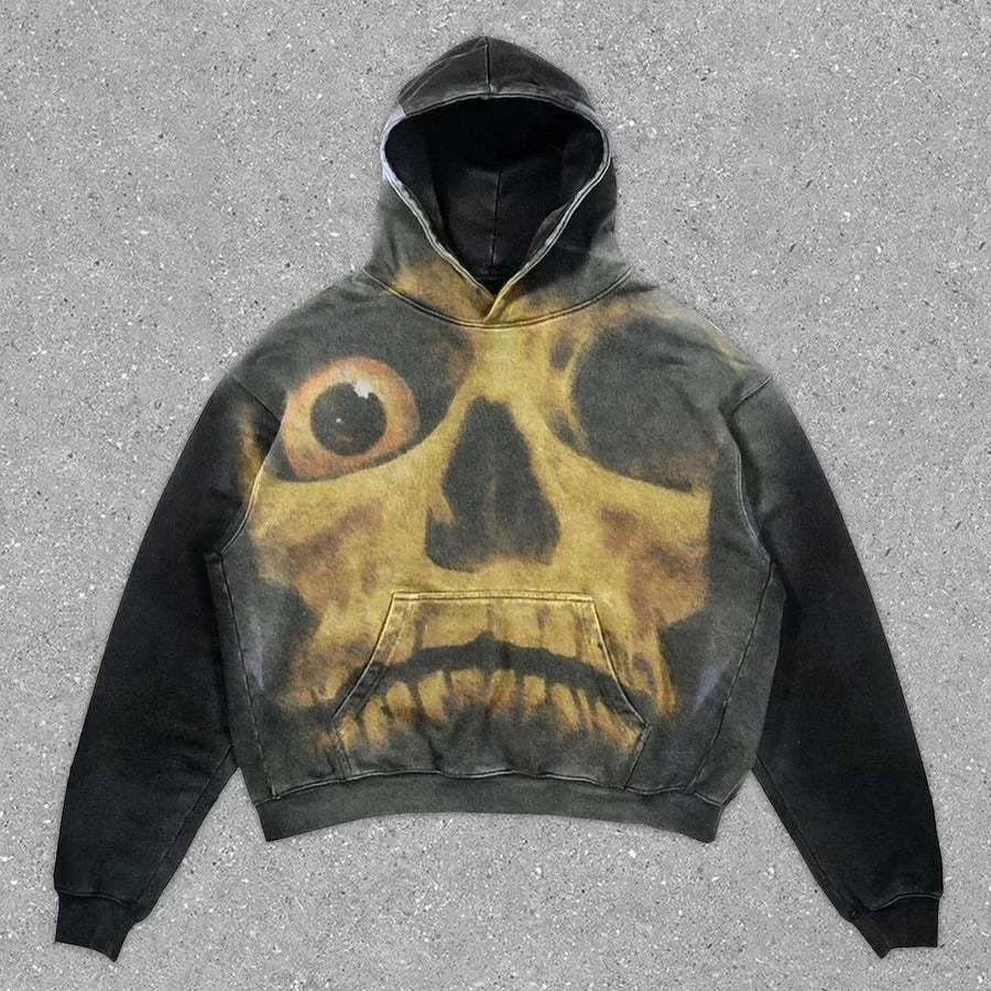 A black hooded sweatshirt with a large graphic of a yellow skull with large eyes on the front against a concrete background, perfect for men's hoodies collections and ideal for four seasons wear, the Maramalive™ Explosions Printed Skull Y2K Retro Hooded Sweater Coat Street Style Gothic Casual Fashion Hooded Sweater Men's Female.