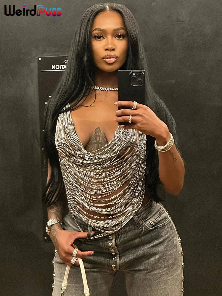 A woman with long black hair takes a mirror selfie. She wears the Maramalive™ Multilayer Chain Women Crop Tops Halter Backless Low Chest Sexy Fashion Hot Girls Rave Party Nightclub Coquette Vest, gray jeans, and various jewelry, perfect for a summer night out at the club.