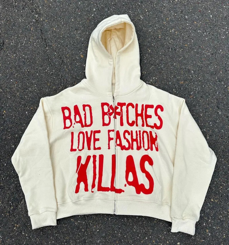 A Maramalive™ y2k Streetwear Goth Letter Print Oversized Hoodie Women 2024 Fashion Casual Loose Harajuku Versatile Zipper Sweatshirt Top with red text saying "BAD B*TCHES LOVE FASHION KILLAS" epitomizes edgy streetwear style, displayed on a gray, textured background.