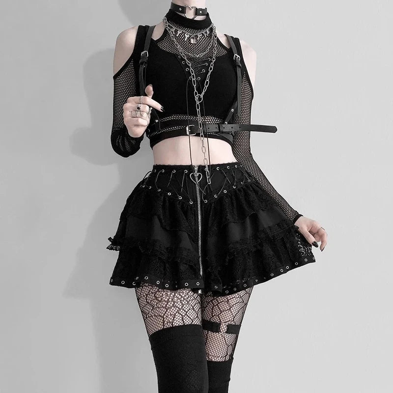 Person wearing a black gothic outfit with a Goth Dark Techwear Fishnet Open Shoulder Halter T-shirts Mall Gothic Grunge Black Bandage Crop Tops Women Punk Sexy Alt Clothing from Maramalive™, fishnet stockings, a layered skirt, and multiple chains and straps for accessories, embodying the Grunge Goth Punk aesthetic seamlessly.