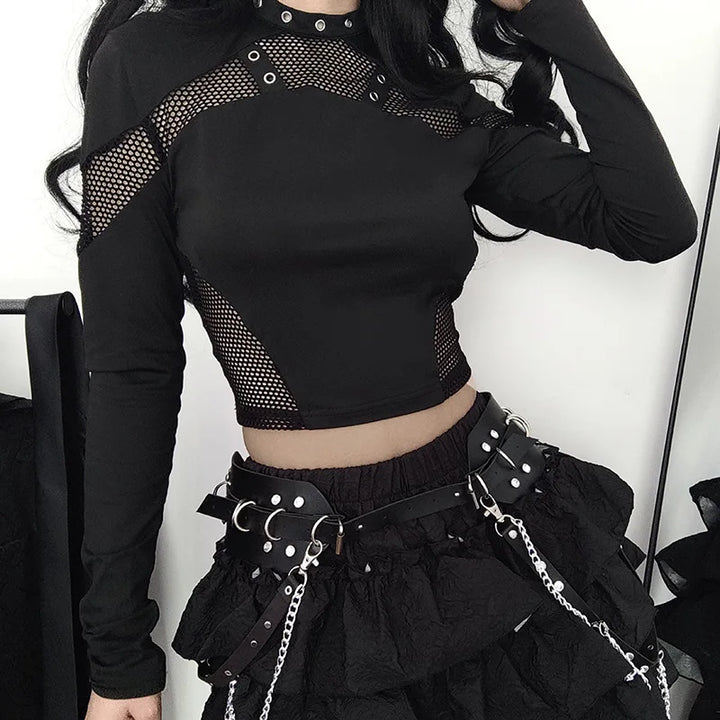 Person wearing a black, long-sleeved Maramalive™ Goth Dark Techwear Cyber Gothic Fishnet Patches T-shirt Punk Grunge Hollow Out Skinny Crop Top Black Eyelet Fashion Alt Clothe, paired with a black skirt adorned with belts and chains—a true embodiment of Gothic streetwear.