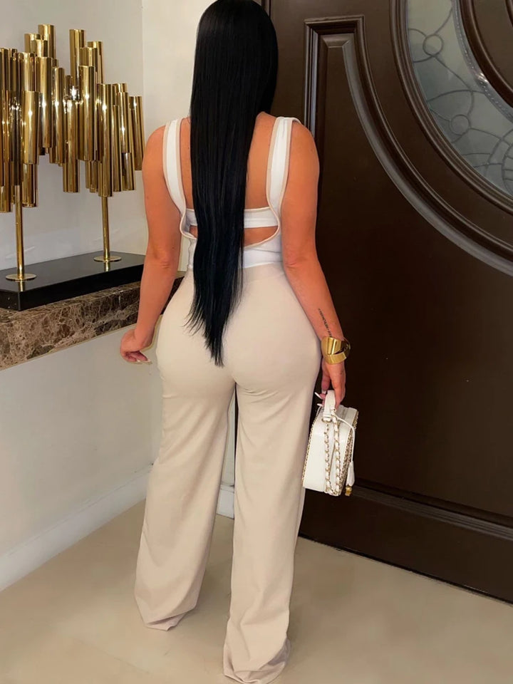 "Elegant woman posing in chic creme and white suspender jumpsuit."