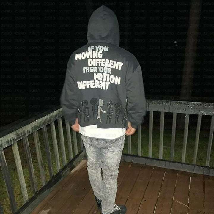 A person wearing a Maramalive™ High Street Y2K Hoodie Women Gothic 90s Print Hoodie Kpop Streetwear Sweatshirt Vintage Clothing Punk Loose Hip Hop Jacket Top with the text "IF YOU MOVING DIFFERENT THEN YOUR M[O]TION DIFFERENT" stands on a wooden deck at night, their back to the camera. Perfect for autumn/winter fashion, this women's pullover adds an edgy vibe to cooler evenings.