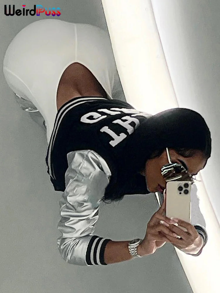 Person wearing a white outfit and a stylish Maramalive™ Fluffy Letter Short Jacket Varsity Women Hipster Leather Sleeve Patchwork Y2K Baseball Casual Wild Streetcoat Outwear taking a selfie in a mirror. The image is taken from an angle above the individual, showcasing their chic autumn/winter outerwear choice.