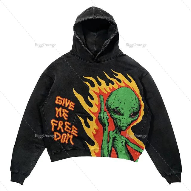 Black hoodie with an illustration of a green alien and flames, featuring the text "GIVE ME FREEDOM" in orange font. This Maramalive™ Explosions Printed Skull Y2K Retro Hooded Sweater Coat Street Style Gothic Casual Fashion Hooded Sweater Men's Female brings a unique touch to your wardrobe.