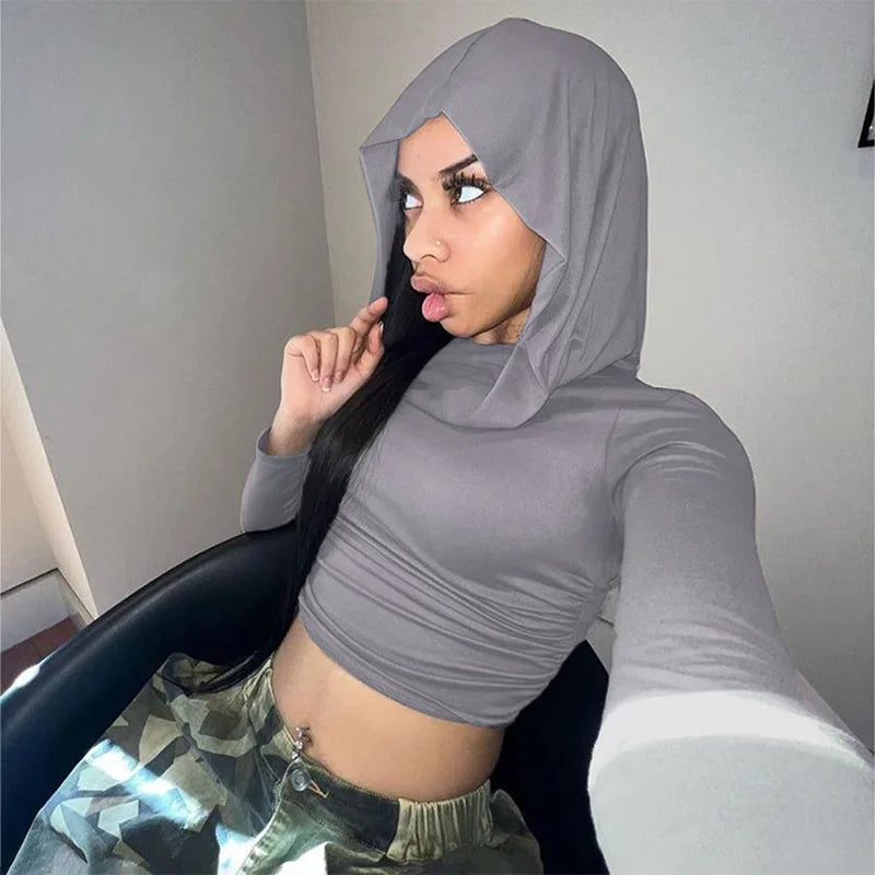 A person wearing a gray 2023 Women Fashion Tight Jogging Sports Hoodie Autumn Solid Color Casual Hooded Long Sleeve Slim Pleated Top Urban Style by Maramalive™ and camo pants takes a selfie while seated, with their hand touching their chin.