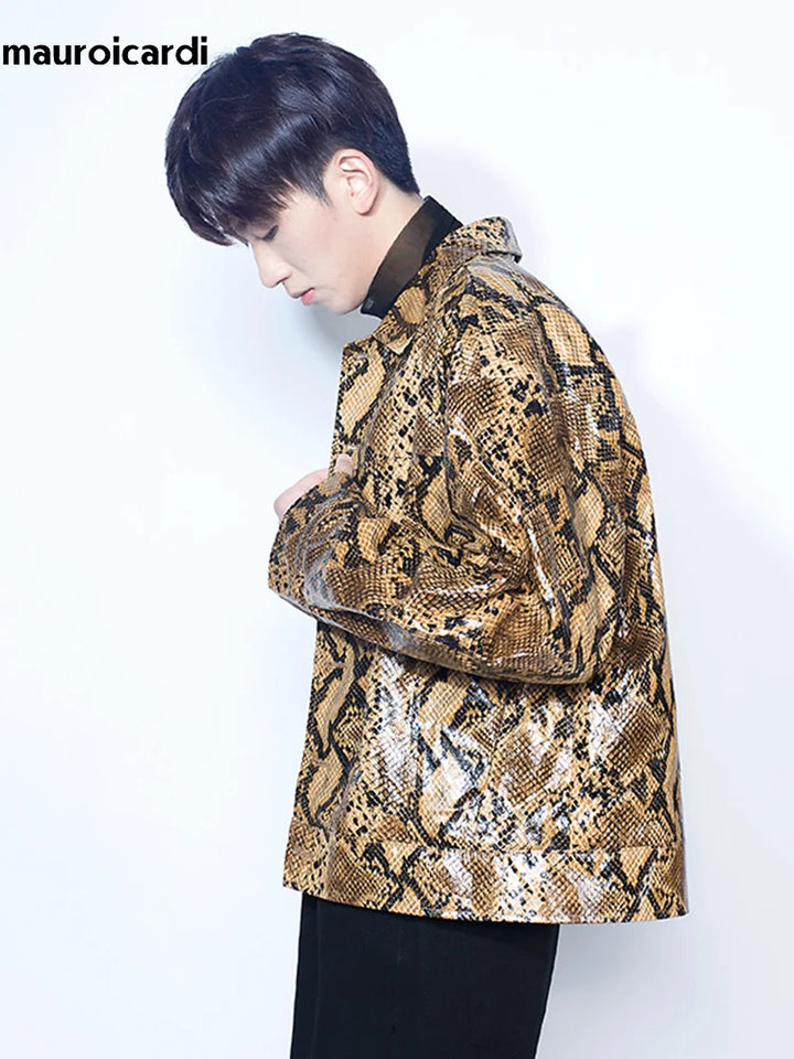 A person with dark hair is facing left, wearing a Loose Cool Shiny Colorful Snakeskin Print Pu Leather Jacket Men Luxury Designer Clothes Streeetwear over a black shirt. The background is plain white with the text "Maramalive™" in the top left corner, embodying youthful casual style.