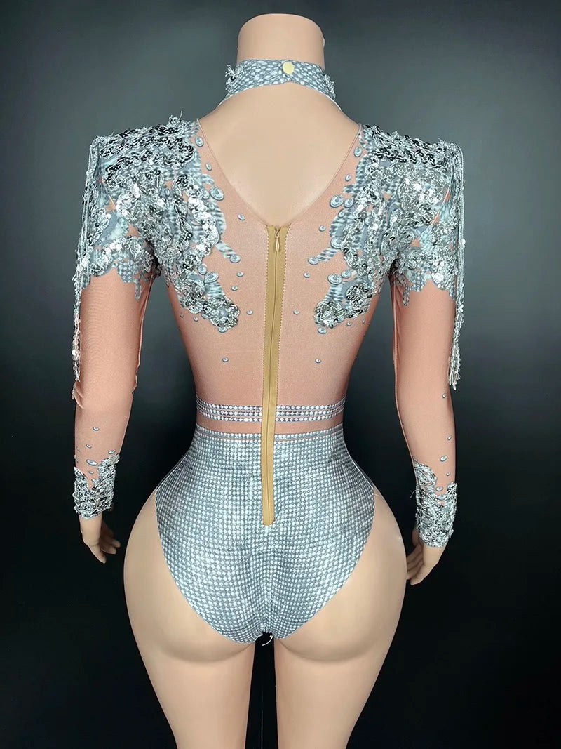 Rear view of a Maramalive™ Flashing Silver Sequins Fringe Spandex Bodysuit Women Dancer Singer Performance Costume High-Neck Long Sleeve Nightclub Stage Wear with sequined, silver embellishments, a sheer back with a visible zipper, and long sleeves featuring matching sequined details. The sexy club style design showcases a high neckline and fitted style.