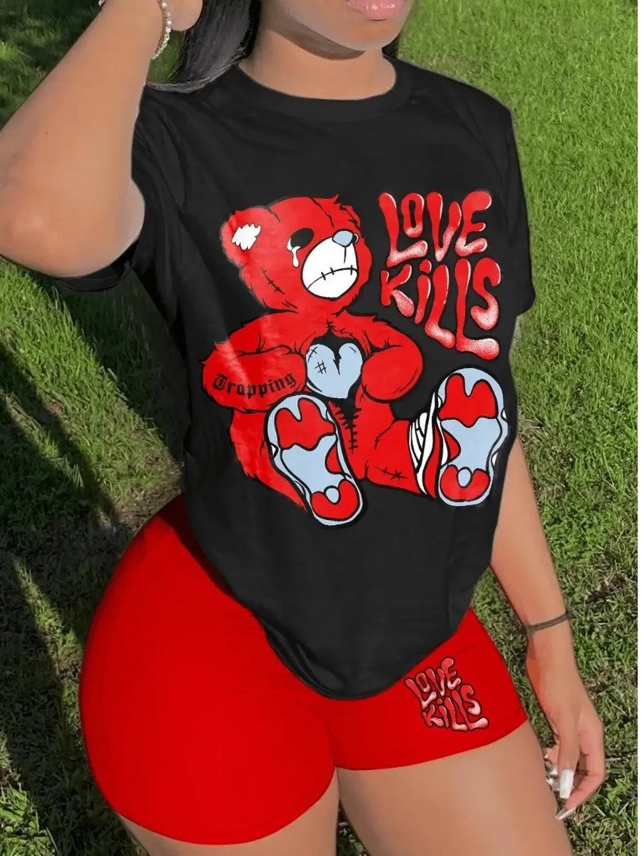 A person embraces a casual style wearing a black t-shirt with a red bear graphic and "Love Kills" text, paired with high-stretch red shorts from LovelyWholesale also featuring "Love Kills" text, standing on grass, dressed in the LW Plus Size Summer Casual 2 Piece Set Letter Print Shorts Set 2 Piece Outfit O Necke Short Sleeve T Shirt Top with short pants by Maramalive™.