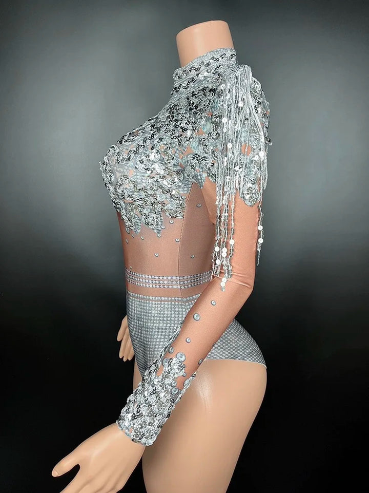 Mannequin displaying a Maramalive™ Flashing Silver Sequins Fringe Spandex Bodysuit Women Dancer Singer Performance Costume High-Neck Long Sleeve Nightclub Stage Wear with intricate silver embellishments and fringe details, reminiscent of a sexy club style, set against a plain black background.