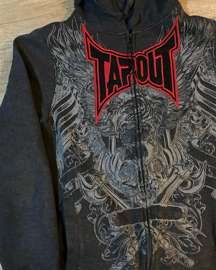A Gothic Skull Pattern Zip Up Hoodies Men Y2K Embroidery Hip Hop Long Sleeve Loose Hooded Streetwear Sweatshirt Casual Vintage New by Maramalive™ with the word "Tapout" in red and white atop a grayscale graphic design of wings and intricate patterns, infused with Vintage Gothic elegance.