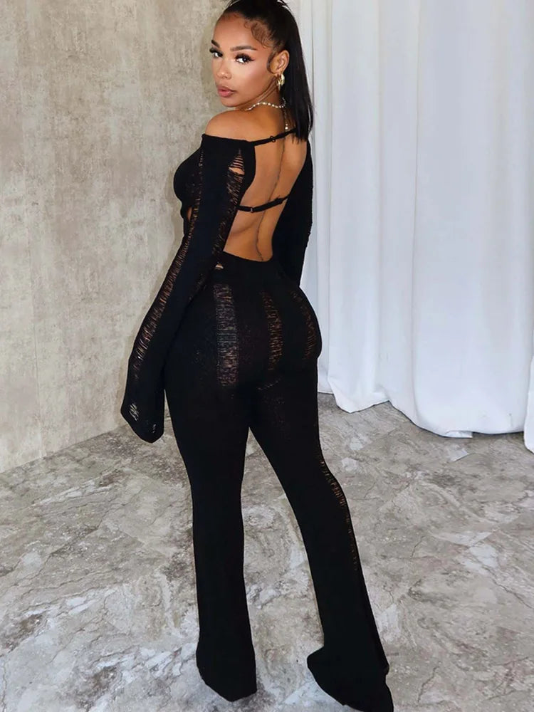 Elegant Woman wearing a black Distressed knit romper with open back.