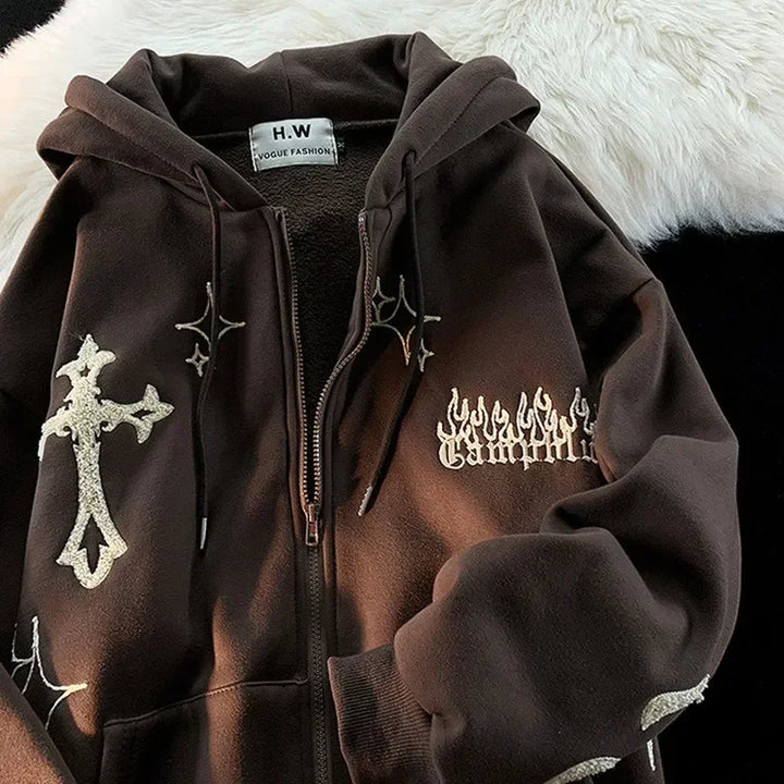 A brown Embroidery Sweatshirt Women Oversized Zip-Up Hoodies Gothic Hip Hop Hooded Streetwear Female Hoodie Y2k Full Jacket with white decorative patches featuring a cross, stars, and flames design. The label inside reads "Maramalive™." This Gothic Hip Hop Streetwear hoodie is laid out on a mix of light and dark fabric.