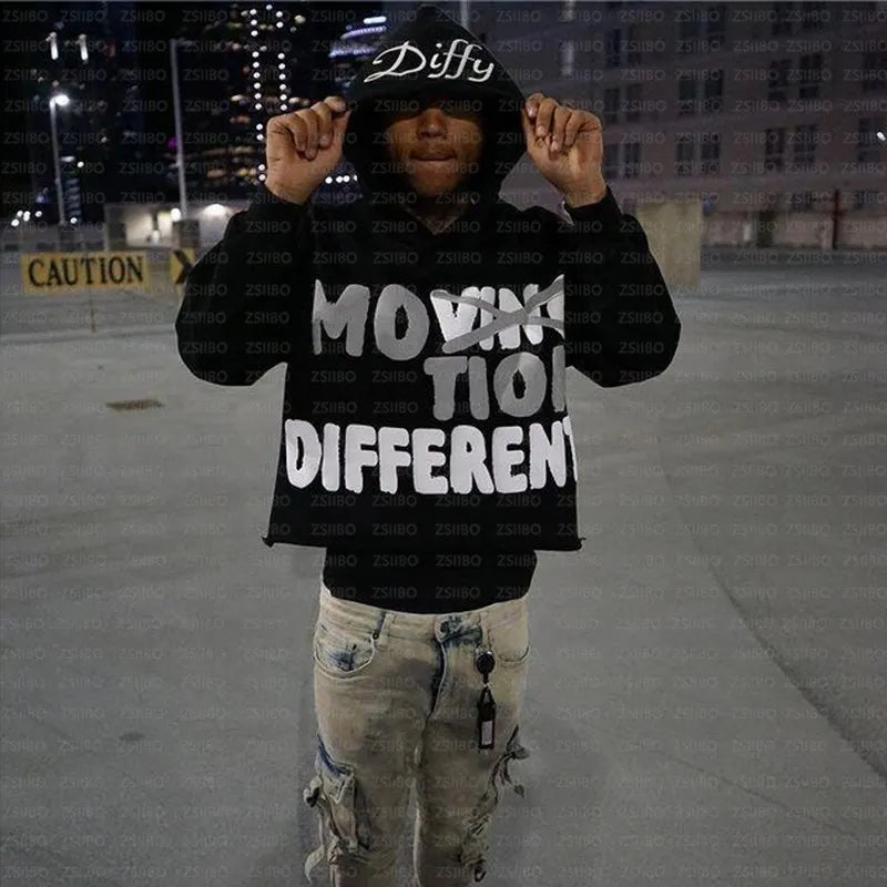 A person standing in an urban setting at night, wearing a Maramalive™ High Street Y2K Hoodie Women Gothic 90s Print Hoodie Kpop Streetwear Sweatshirt Vintage Clothing Punk Loose Hip Hop Jacket Top that reads "Movin' Different" and holding the hood with both hands. Caution tape and lit buildings are visible in the background, emphasizing the edgy vibe of Autumn/Winter fashion.