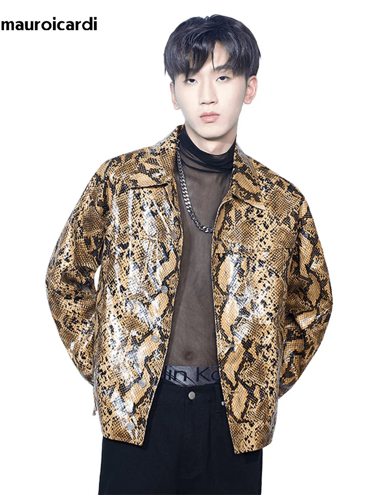 A person stands wearing a Loose Cool Shiny Colorful Snakeskin Print Pu Leather Jacket Men Luxury Designer Clothes Streetwear by Maramalive™ over a black sheer top and black pants, epitomizing youthful casual style. Their hair is dark and styled simply. The background is white with "mauroicardi" written in the top left corner.