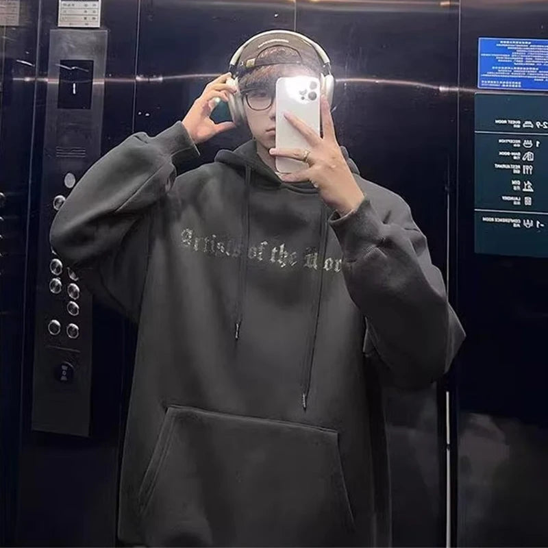 Person wearing a Maramalive™ Autumn Goth Graphic Print Hooded Sweatshirts For Men Oversized Y2K Streetwear Hoodies New In Fashion Pullover Hoodie, glasses, and headphones, taking a mirror selfie inside an elevator.