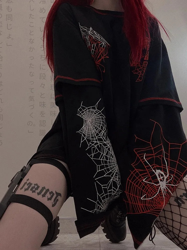 Person wearing a Maramalive™ Deeptown Y2k Gothic Spider T Shirt Women Goth Dark Streetwear Design Tees Black Long Sleeve Top 2023 Autumn Spring and black shorts, showing a thigh tattoo, Y2K style harness straps sitting on the floor.
