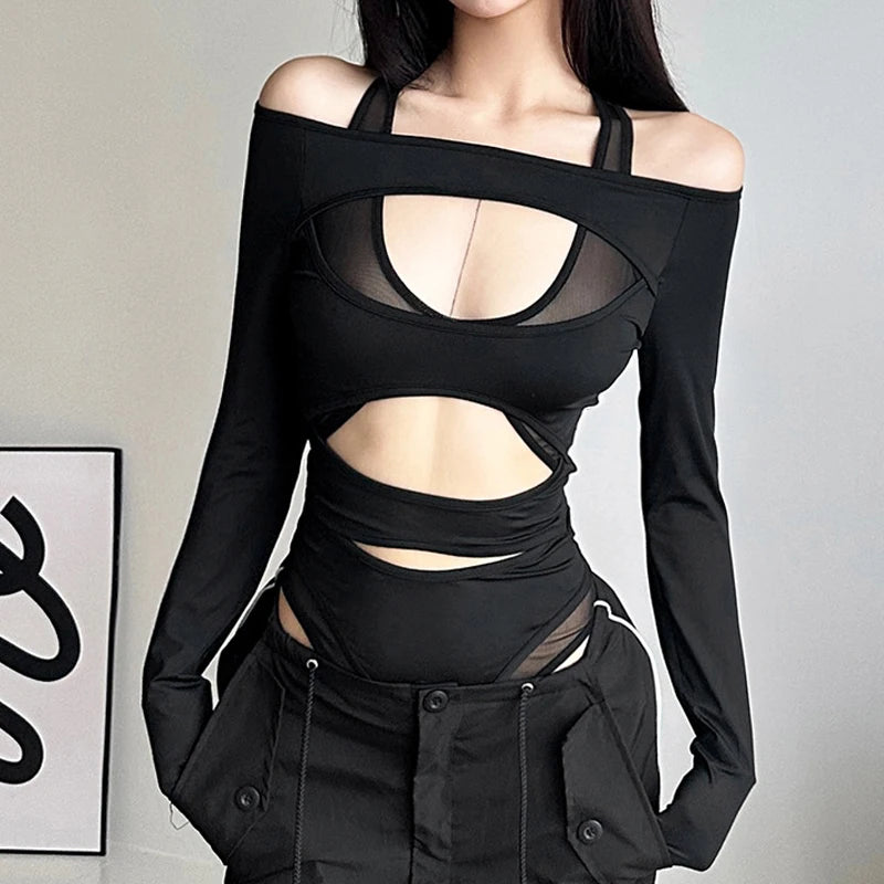 A person in a black, Goth Dark Cyber Y2k Punk Hollow Out Sexy Bodysuits Mall Gothic Bodycon Mesh Sheer T-shirts Women Long Sleeve Patchwork Bodysuit by Maramalive™ with long sleeves and high-waisted black pants.