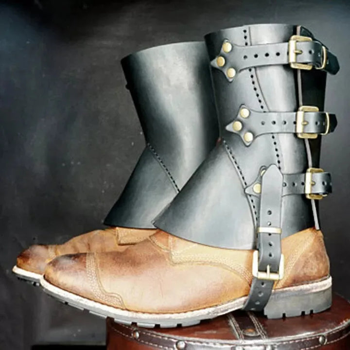 A pair of Maramalive™ 1 Pair Medieval Knight Warrior Gaiters Armor Leather Boot Shoes Cover Waterproof Leg Guards Renaissance Costume Accessory Larp with black faux leather gaiters strapped around the ankles and legs, secured with brass buckles. Perfect for historical costumes or unisex pirate leggings.