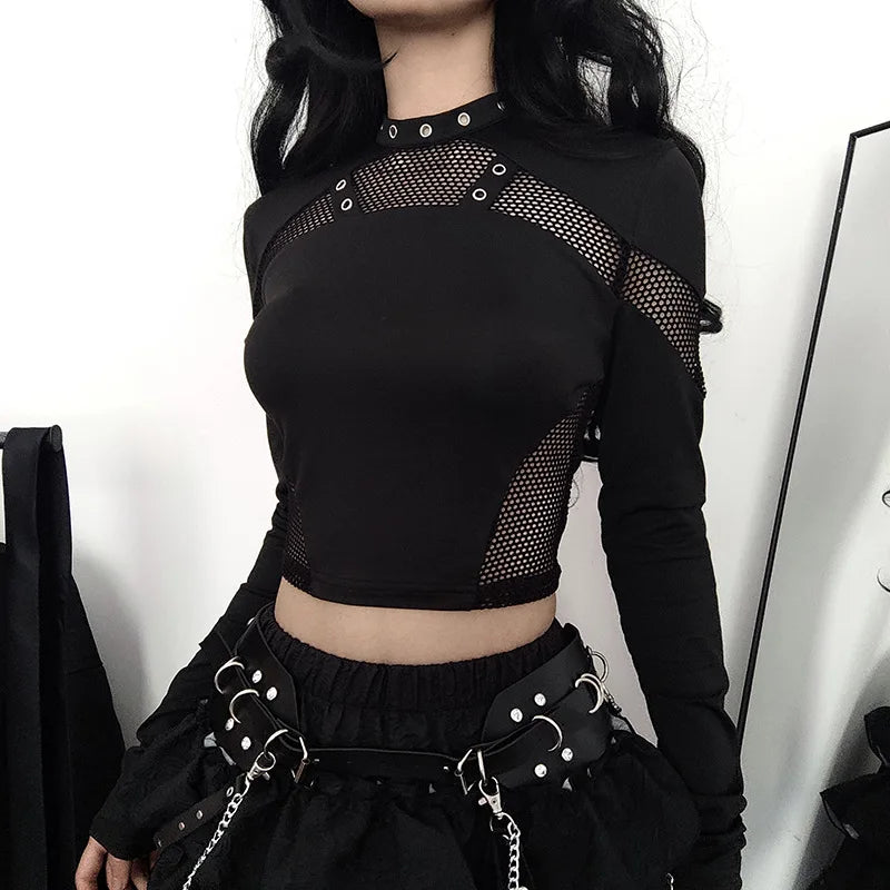 A person with long black hair, clad in a Maramalive™ Goth Dark Techwear Cyber Gothic Fishnet Patches T-shirts Punk Grunge Hollow Out Skinny Crop Tops Black Eyelet Fashion Alt Clothe and a skirt adorned with multiple belt buckle details, embodies Gothic streetwear. The ensemble exudes goth dark vibes, perfect for those who love edgy fashion.