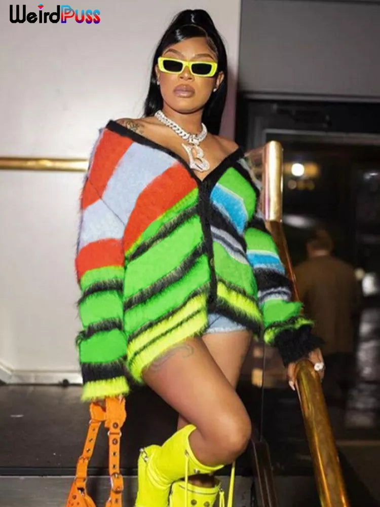 Person standing on stairs wearing a colorful striped outfit, yellow sunglasses, and neon yellow boots. Holding an orange handbag, they have a confident expression. The background is an indoor setting featuring a stylish 2022 Cardigan Sweater Y2K Women Button Contrast Color Patchwork V-Neck Lantern Sleeve Top Street Hipster Loose Coat from Maramalive™ that adds to the ensemble's boldness.