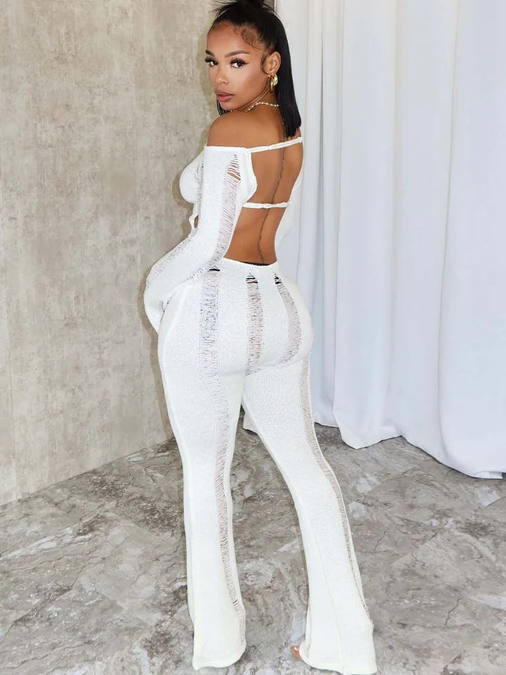 Elegant Woman wearing a White Distressed knit romper with open back.