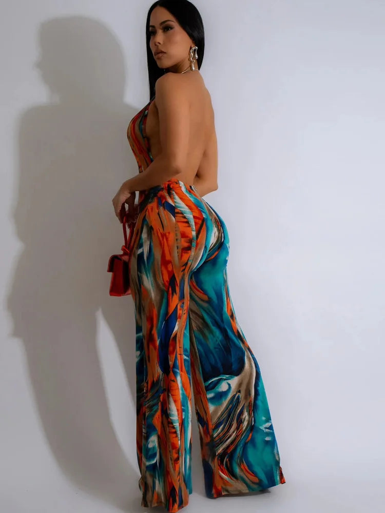 Model wearing a Tropical floral print romper, halter neck, backless.