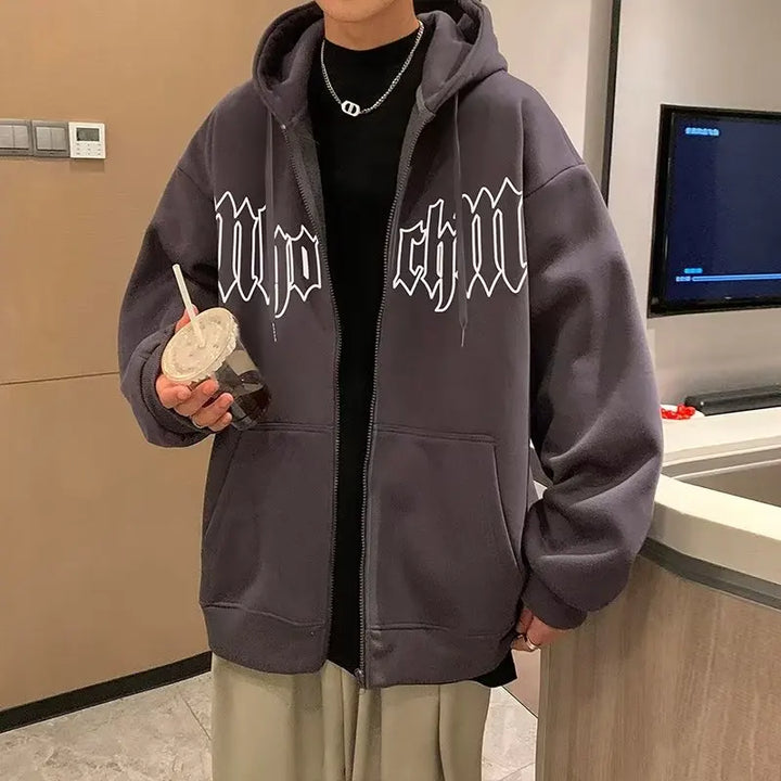 Person wearing a dark Maramalive™ Autumn Men's Letter Foam Print Zip up Hoodies Y2K Goth Streetwear Loose Sweatshirts Female Hip Hop Oversized Hoodie Tracksuit, holding a drink with a straw, standing in a modern indoor setting.
