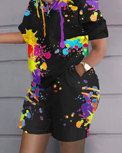Person wearing a Maramalive™ Plus Size Matching Sets Women Graffiti Tie Dye Shirts Tops And Short Pants Female Fashion Tracksuits 2023 Summer Two Piece Sets in a casual style, standing against a grey wall.
