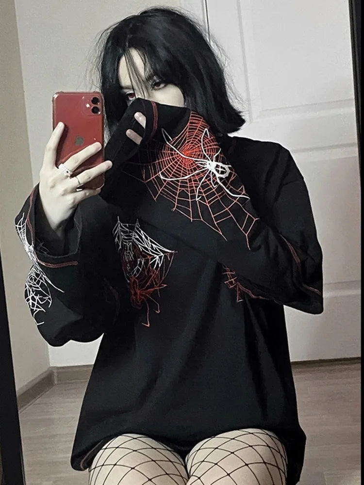 Person with black hair takes a mirror selfie with a red phone, wearing an oversized black shirt, specifically the Maramalive™ Deeptown Y2k Gothic Spider T Shirt Women Goth Dark Streetwear Design Tees Black Long Sleeve Top 2023 Autumn Spring, and fishnet stockings.
