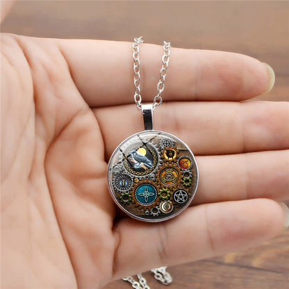 A hand holding a Steampunk Time Stone Necklace by Maramalive™ with a clock and gears on it.