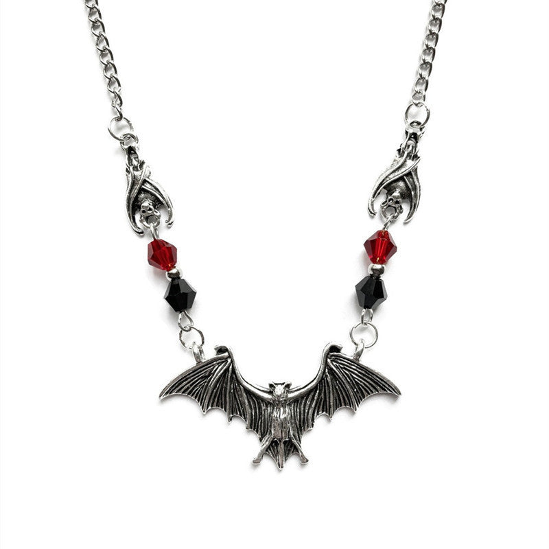 A black and red Bat Wing Necklace from Maramalive™ on a mannequin.