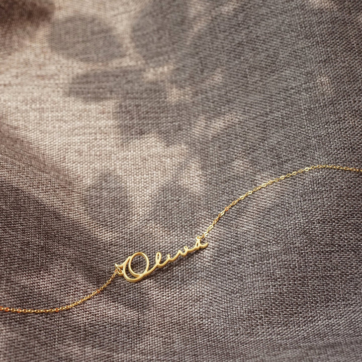 A woman wearing a Maramalive™ Women's Personalized Name 18k Gold Necklace.