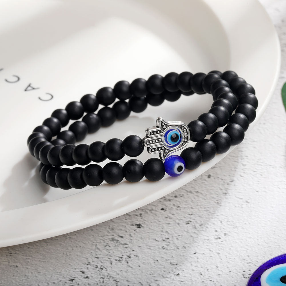 A pair of Turquoise Glaze Beaded Devil's Eye Bracelet Set - 6cm Black Glass bracelets by Maramalive™ on a plate.