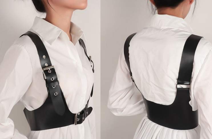 A woman wearing a Gothic Bold Strap Vest - Punk Vegan-Friendly Leather Body Belt by Maramalive™ and a white shirt.
