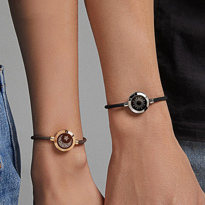 Two people holding hands and wearing Maramalive™ Sun-Moon Smart Sensing Couple Bracelets, staying connected across the miles.