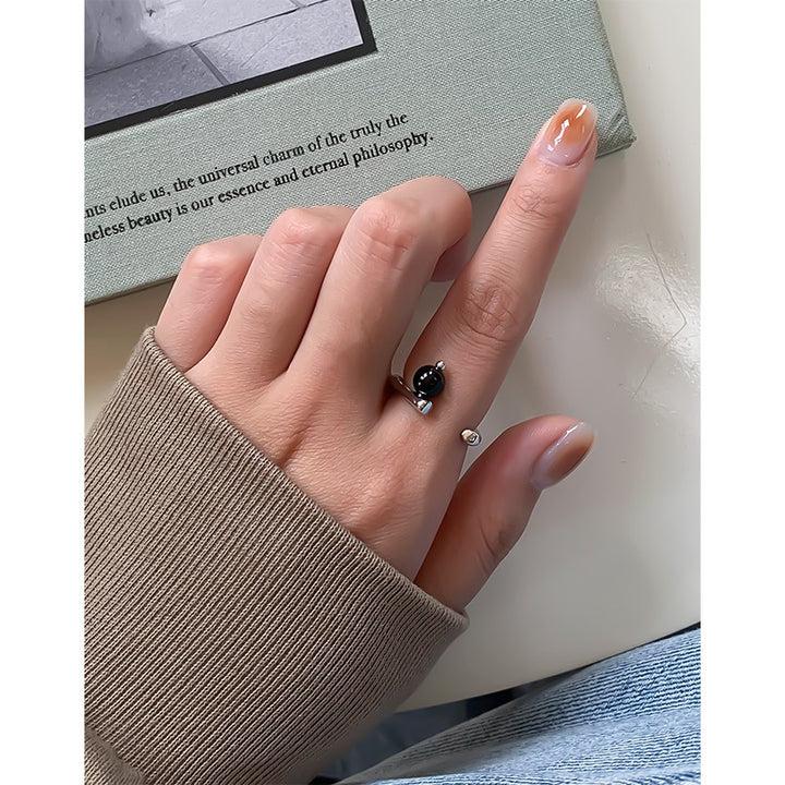 A woman's hand holding a Niche Light Luxury Geometric Irregular Black Onyx Ring by Maramalive™.