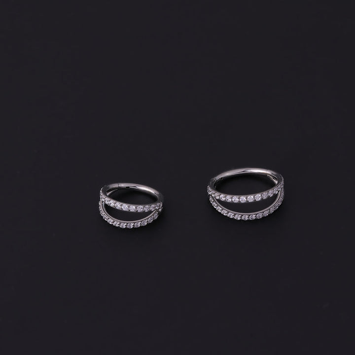 A set of Maramalive™ Stainless Steel Double Row Carved Zircon Seamless Nose Rings on a black surface.