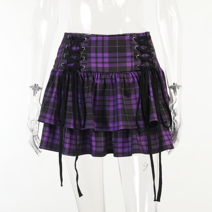 A woman in a Gothic Lace-up Plaid Skirt - Punk Dark Tartan Mini Skirt by Maramalive™ holding a cup.
