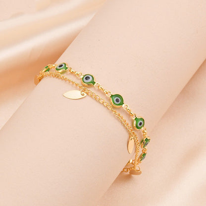 A Titanium Gold Oval Twin Bracelet - Elegant & Durable 14K Gold adorned with green eyes and leaves made by Maramalive™.