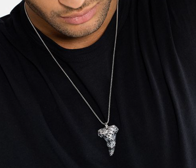 A man wearing a Maramalive™ Maori Tooth Pendant Fashion Jewelry Ethnic Retro Necklace.