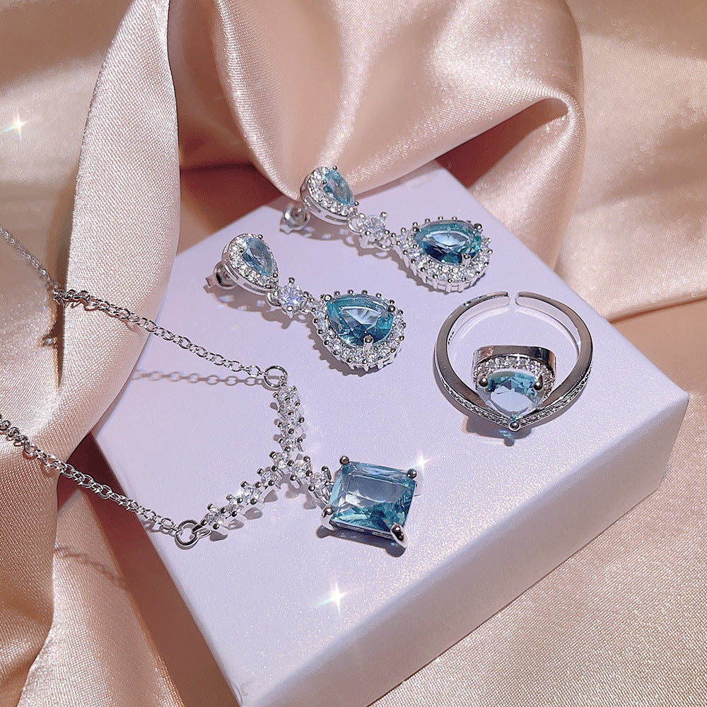 A Women's Inlaid Blue Zircon Ring Earrings Necklace set on a satin from Maramalive™.