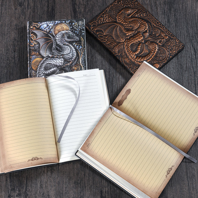 Three Maramalive™ Vintage Anaglyph Dragon Notebook Retro Planners in Bronze lined up next to each other on a table.