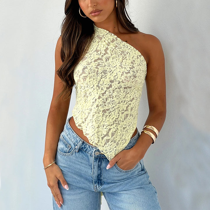 A person wearing a Maramalive™ Ins Lace Backless Top Summer Solid Color Waistless Asymmetrical Sloped Neck Vest Streetwear Womens Clothes and blue jeans, exuding street hipster style, stands against a plain background.