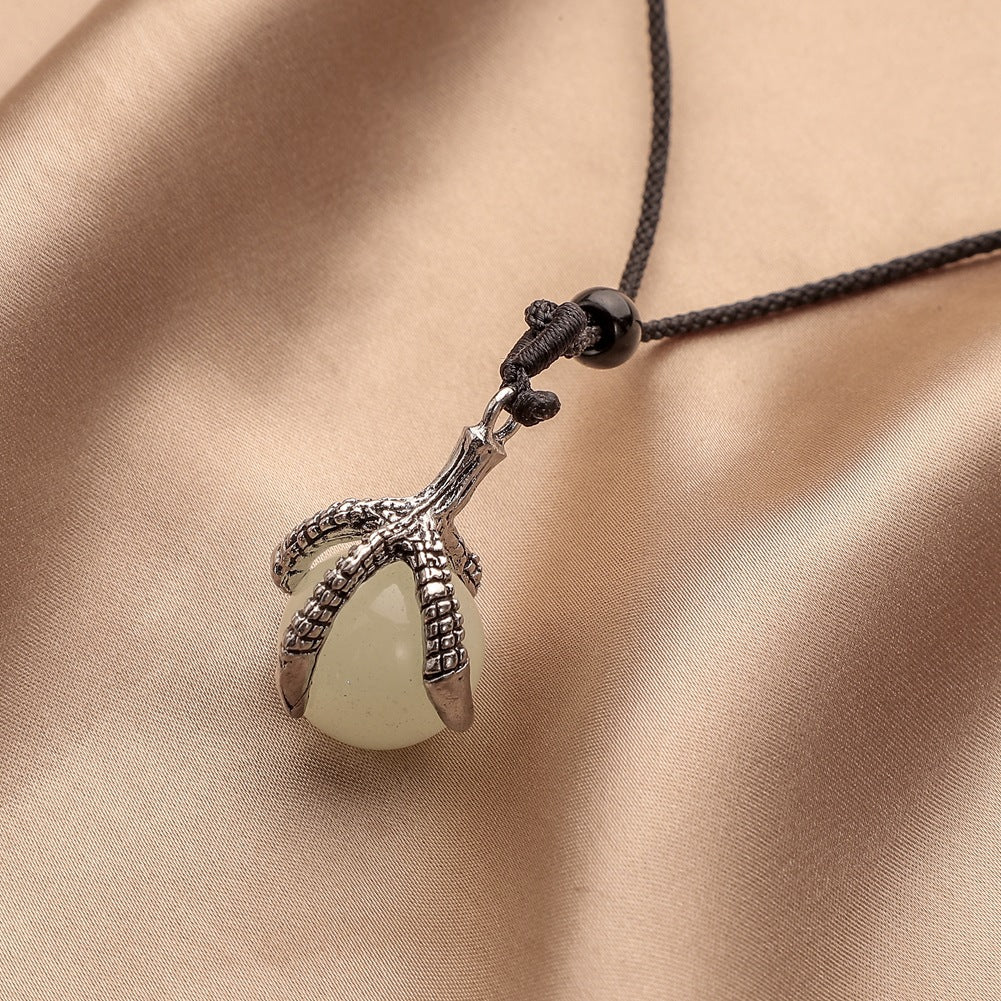 A person wearing a Dragon Claw Pearl Pendant Necklace which glows in the dark from Maramalive™.